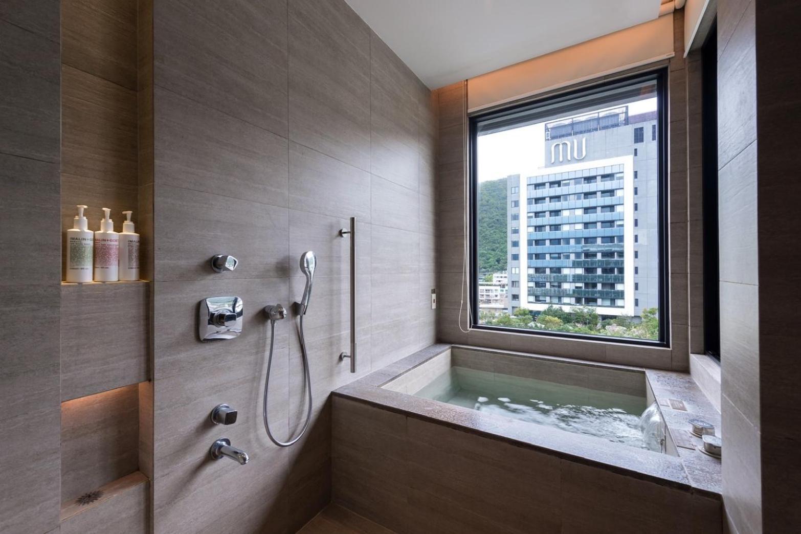Mu Jiaoxi Hotel Kültér fotó A modern Japanese-style bathroom with a deep bathtub
