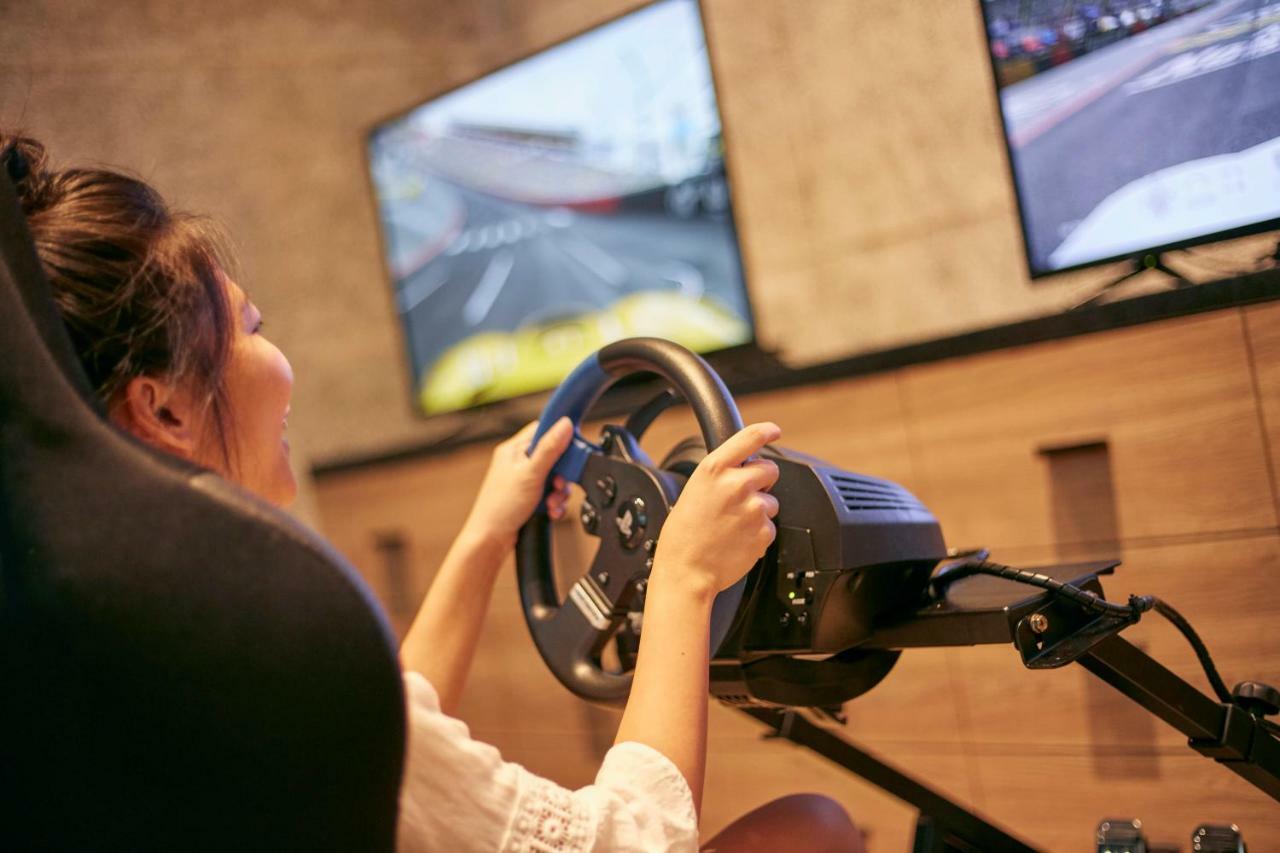 Mu Jiaoxi Hotel Kültér fotó A woman playing a racing video game